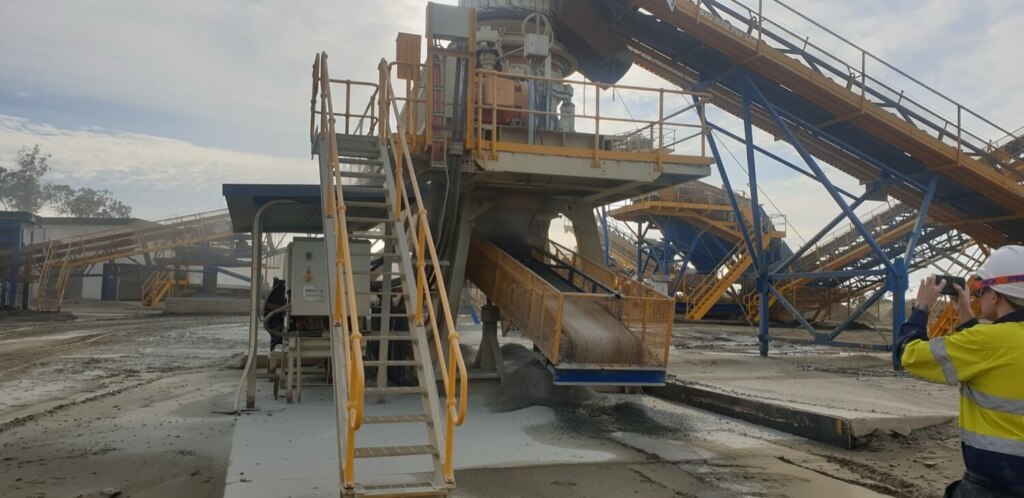 An engineering consultant is standing next to a concrete mixer.